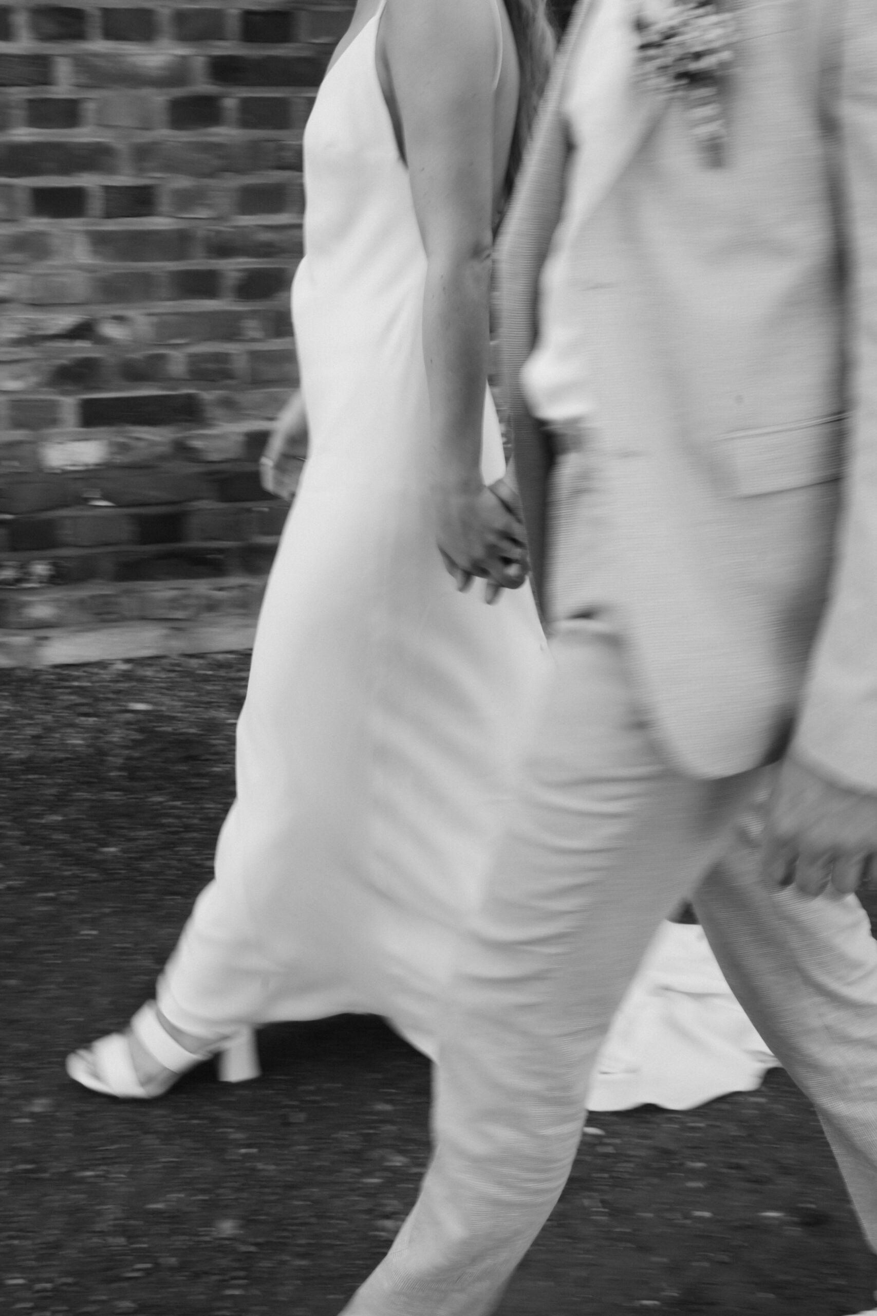 verschwommendes Bild eines gehenden Brautpaar bei einer Sommerhochzeit auf Haus Hohenbusch