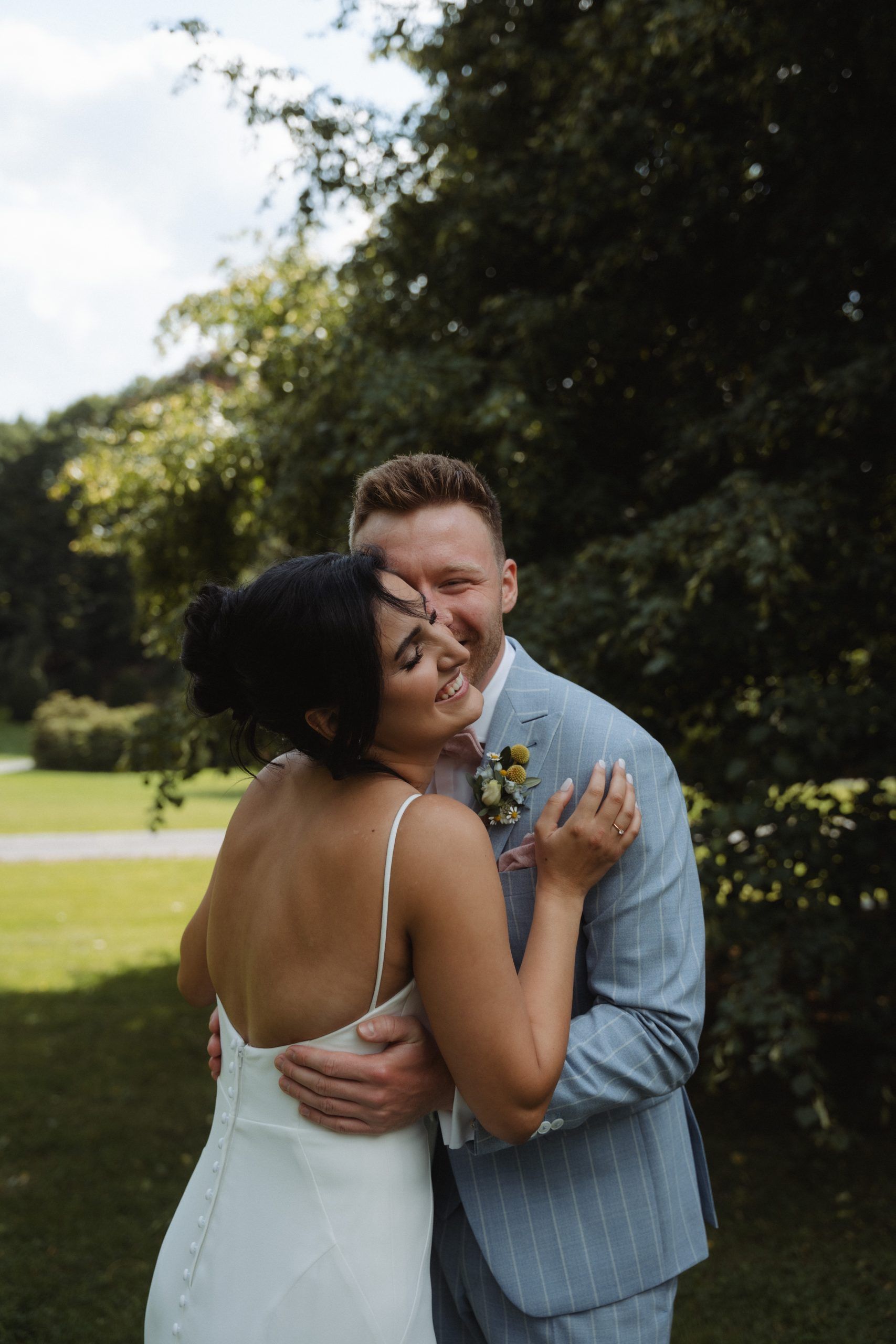 Lachendes Brautpaar im Garten von Schloss Grünewald am Hochzeitstag