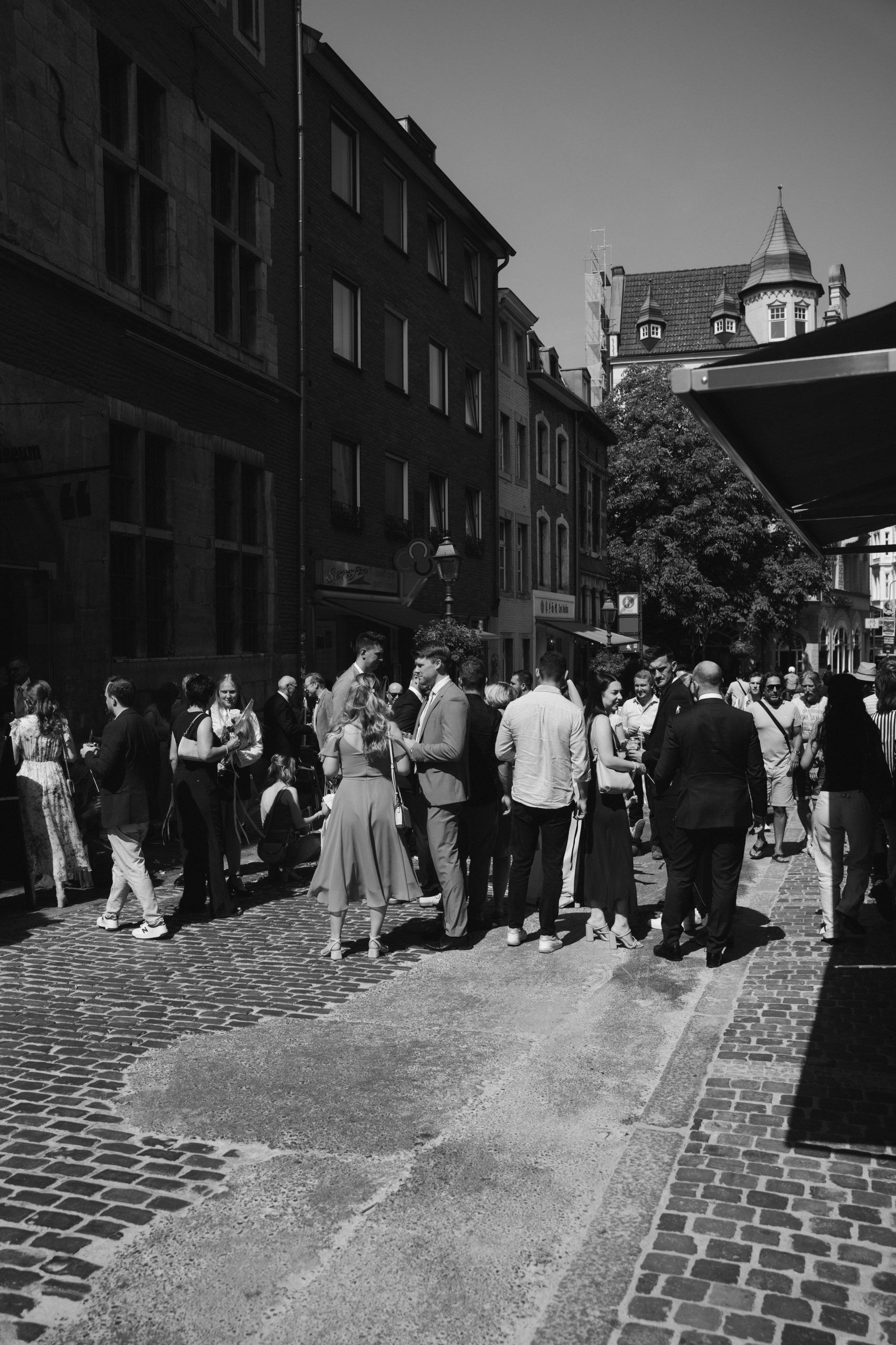 Hochzeitsgesellschaft vor dem Standesamt Zeitungsmuseum Aachen auf Kopfsteinpflasterstraße