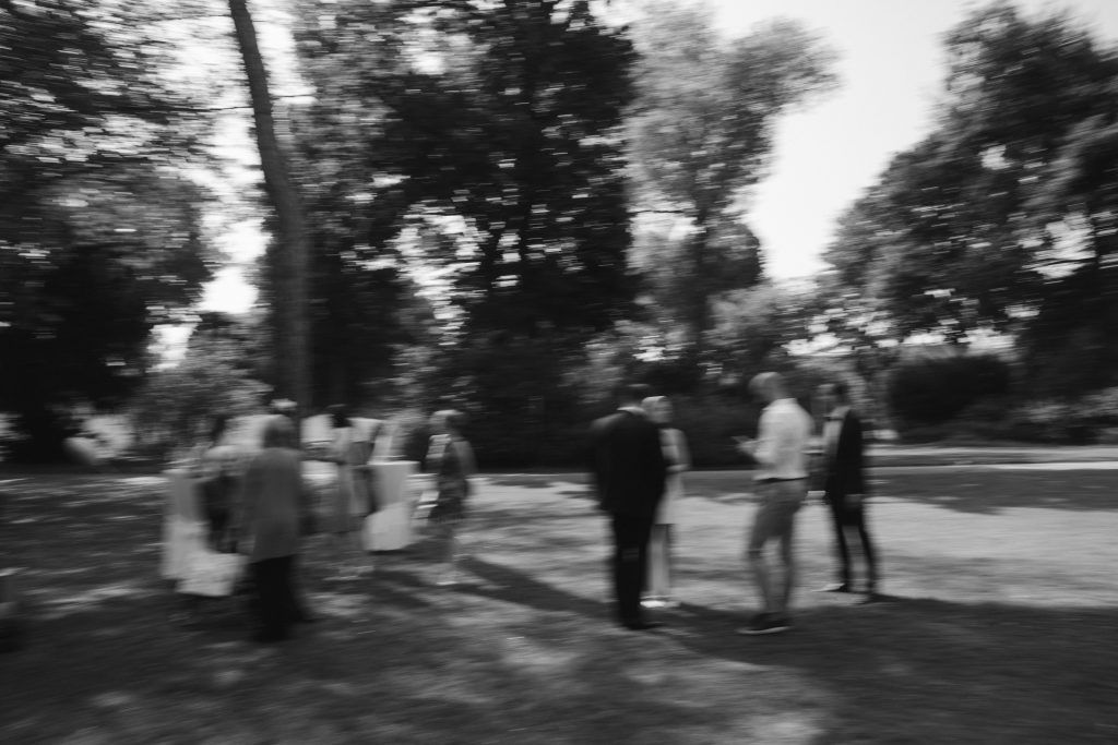 Verschwommene Szene mit Hochzeitsgästen im Park bei Tageslicht