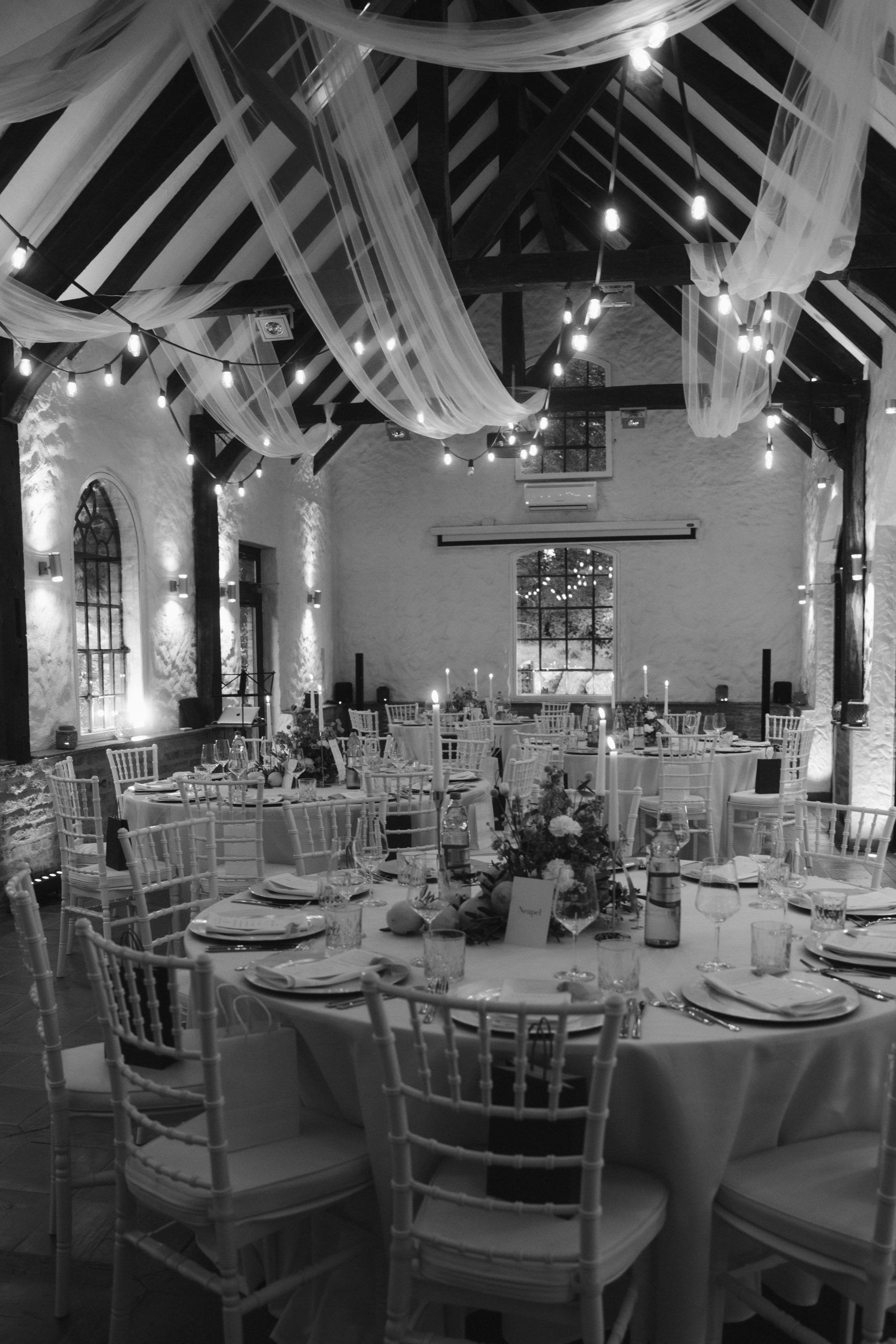 Festlich gedeckter Hochzeitssaal im Schloss Grünewald mit Lichterketten und Floristik