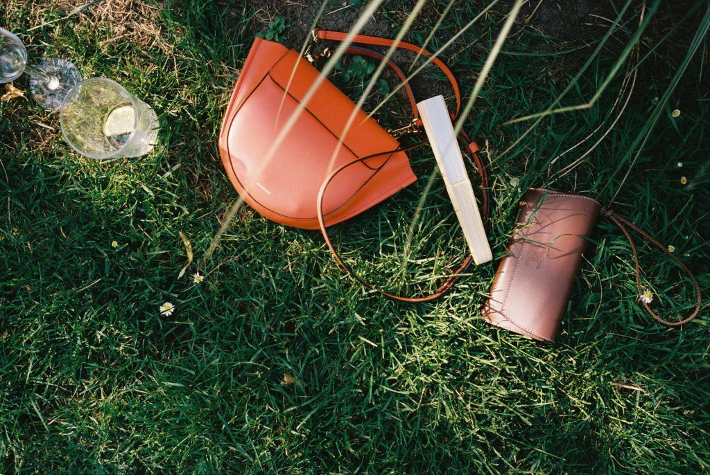 Handtaschen und persönliche Accessoires der Hochzeitsgäste im Gras